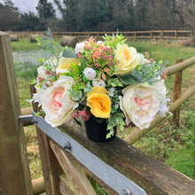 a grave pot with flowers featuring  artificial silk blooms