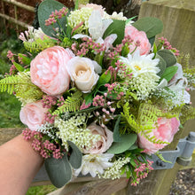 A brides bouquet of pink and ivory faux silk artificial flowers