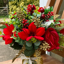 A Christmas artificial handtied flower arrangement in glass vase