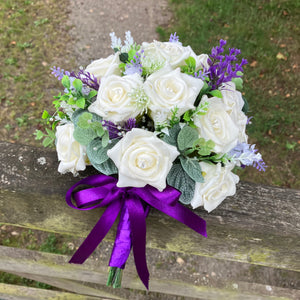 A wedding bouquet of artificial ivory roses & lavender flowers