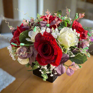 a flower arrangement of red & ivory roses