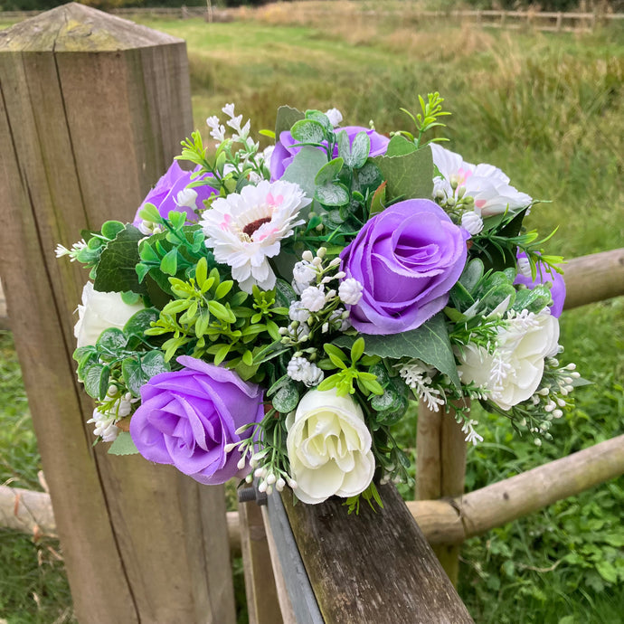 A graveside flower arrangement in black plastic pot