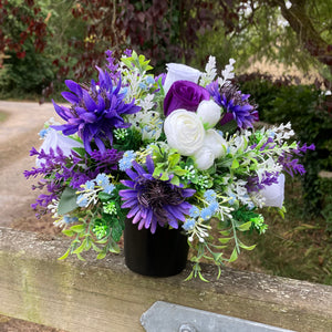 a grave pot with white artificial silk cornflowers and rose blooms