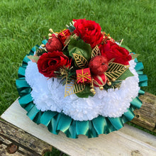 A christmas graveside memorial posy of red roses and carnations