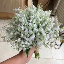 A wedding bouquet of pure white artificial lily of the valley flowers