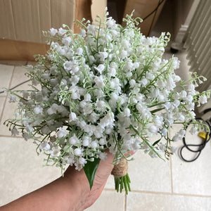 A wedding bouquet of pure white artificial lily of the valley flowers