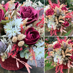 A dried flower arrangement of burgundy and red flowers
