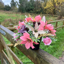 A Christmas graveside flower arrangement in black pot