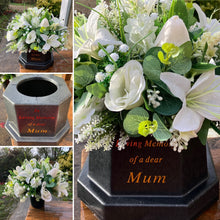 Ivory memorial flowers arranged in black plastic pot