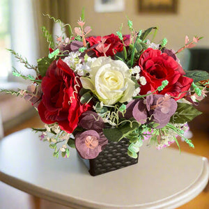 a flower arrangement of red & ivory roses