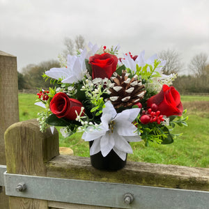 A memorial Christmas flower rose and poinsettia arrangement