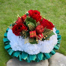 A christmas graveside memorial posy of red roses and carnations