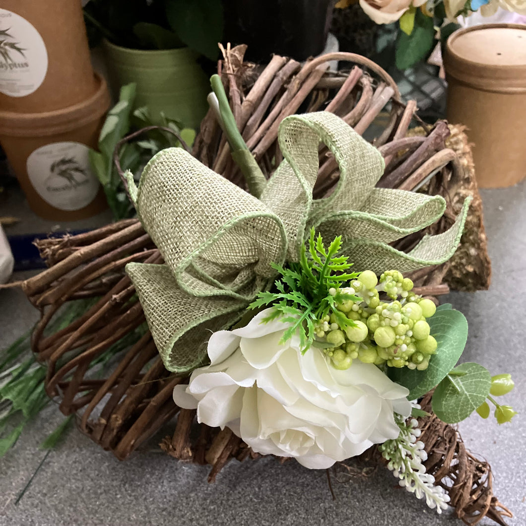 A heart wreath with cluster of flowers and foliage