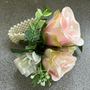 wrist corsage features blush pink silk rose flowers on pearl bracelet