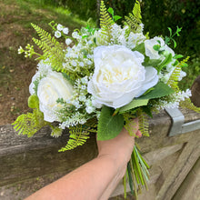 A wedding bouquet collection of white artificial silk roses peonies and gyp