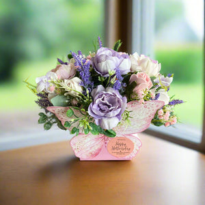 An artificial flower arrangement in butterfly container