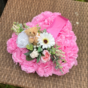 a personalised memorial heart of artificial silk roses and carnations in shades of pink