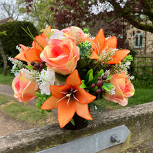 a grave pot with flowers featuring  artificial silk blooms