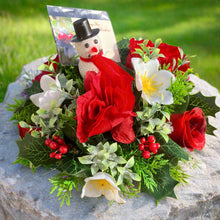 A graveside flower arrangement in black plastic pot