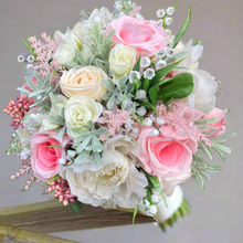 a brides wedding bouquet of artificial flowers  in shades of ivory & pink