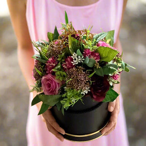 A flower arrangement in black hat box