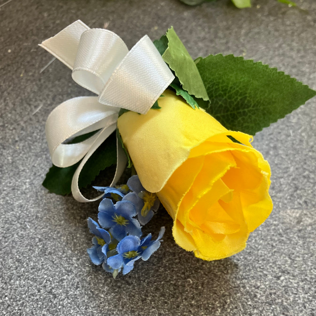 an artificial silk buttonhole featuring a single yellow rose bud