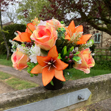 a grave pot with flowers featuring  artificial silk blooms