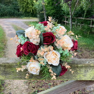 A wedding bouquet of artificial silk burgundy & orange flowers