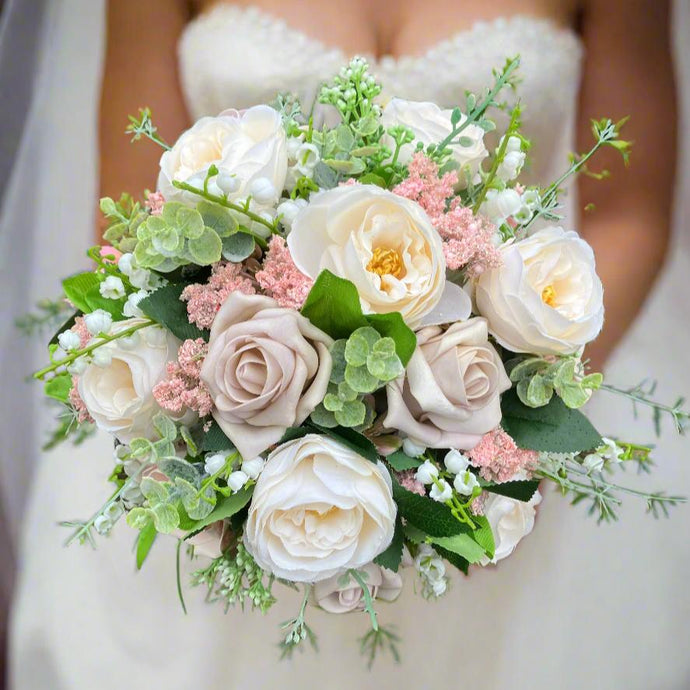 brides wedding bouquet of pink and ivory artificial flowers