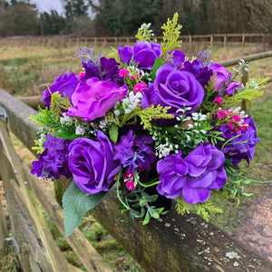 a silk graveside flower arrangement in black pot