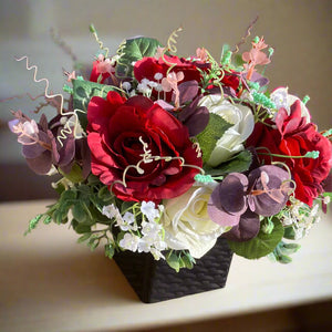 a flower arrangement of red & ivory roses