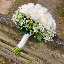 A wedding bouquet of artificial faux silk roses edged with Gypsophila