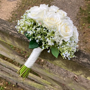 A wedding bouquet of artificial faux silk roses edged with Gypsophila