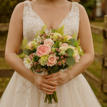A brides bouquet of pink and ivory faux silk artificial flowers