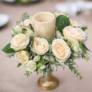 A table centrepiece of ivory flowers, foliage & led candle