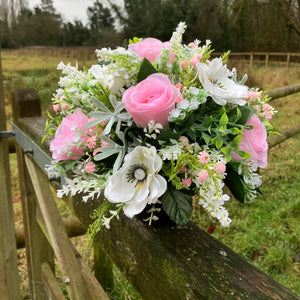 a graveside artificial flower arrangement in shades of cream and pink