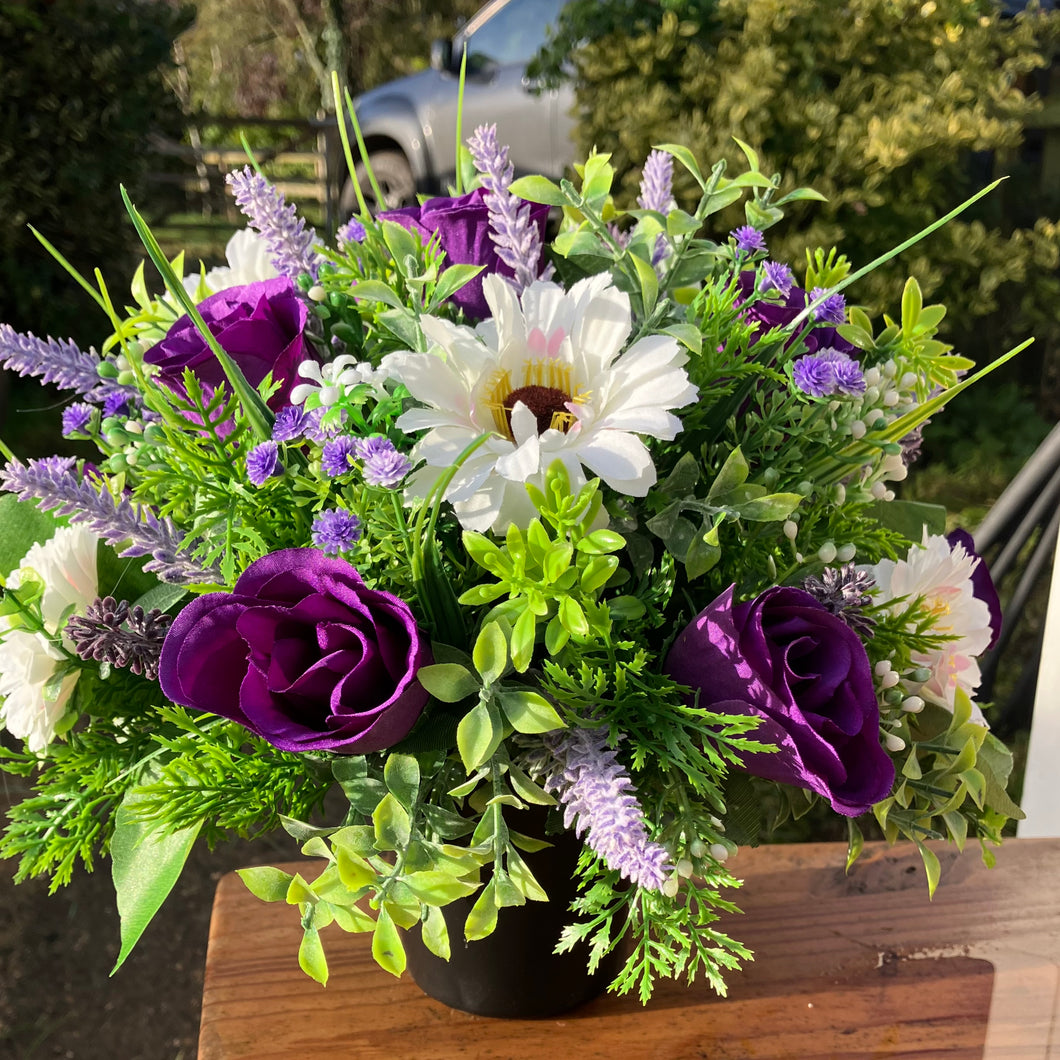 a grave pot with cream artificial silk gerbera and rose blooms