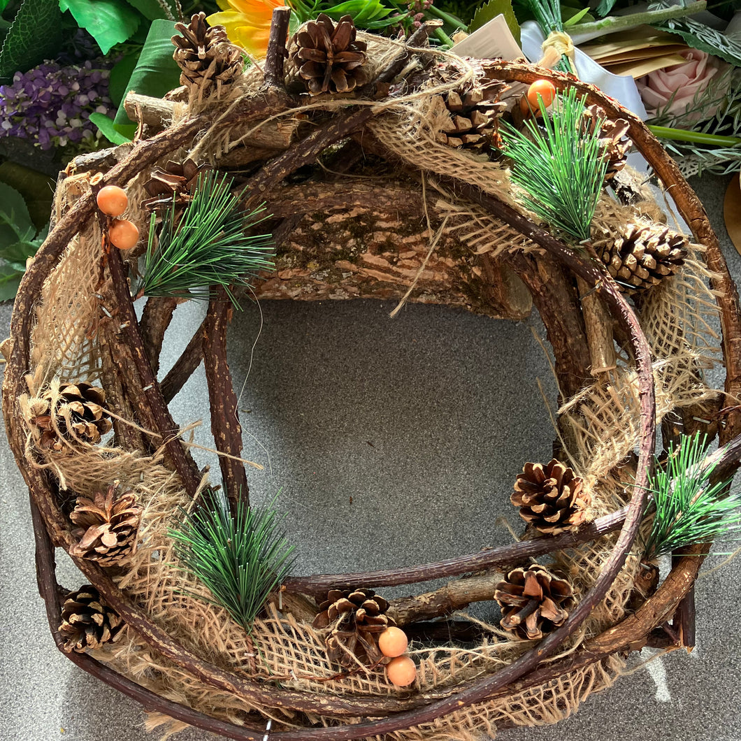 A natural wooden christmas wreath with cones berries and jute decoration