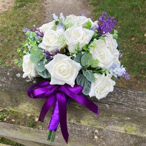 A wedding bouquet of artificial ivory roses & lavender flowers