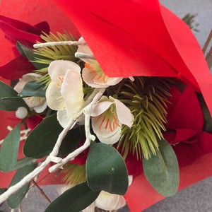 An Artificial flower bunch of christmas roses mistletoe and poinsettia