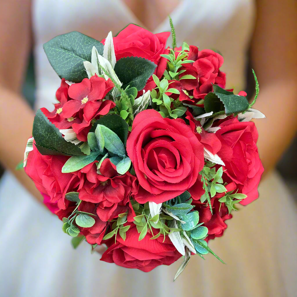 A wedding bouquet of artificial faux silk red roses and hydrangea flowers
