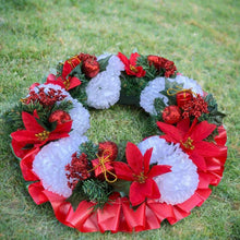 a memorial christmas wreath featuring baubles, cones and poinsettia