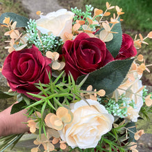 A wedding bouquet of artificial silk burgundy & orange flowers