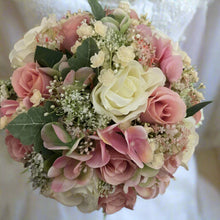 A wedding bouquet of ivory and dusky pink artificial flowers