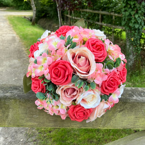 A brides bouquet featuring apricot, coral and peach roses & hydrangea