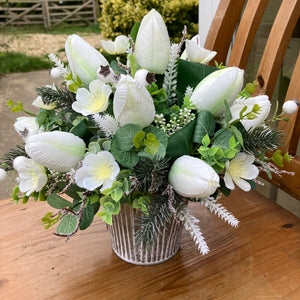 A Christmas flower arrangement featuring artificial white tulip flowers