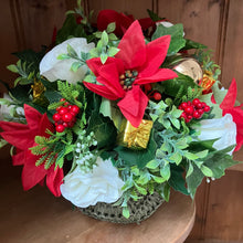 a christmas table centrepiece of red and ivory flowers