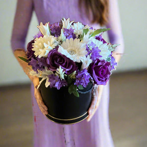 A flower arrangement in black hat box