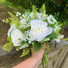 A wedding bouquet collection of white artificial silk roses peonies and gyp
