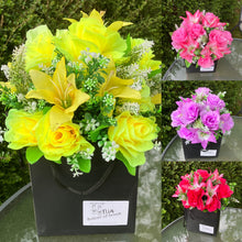 flower arrangement of artificial roses and lilies in black box